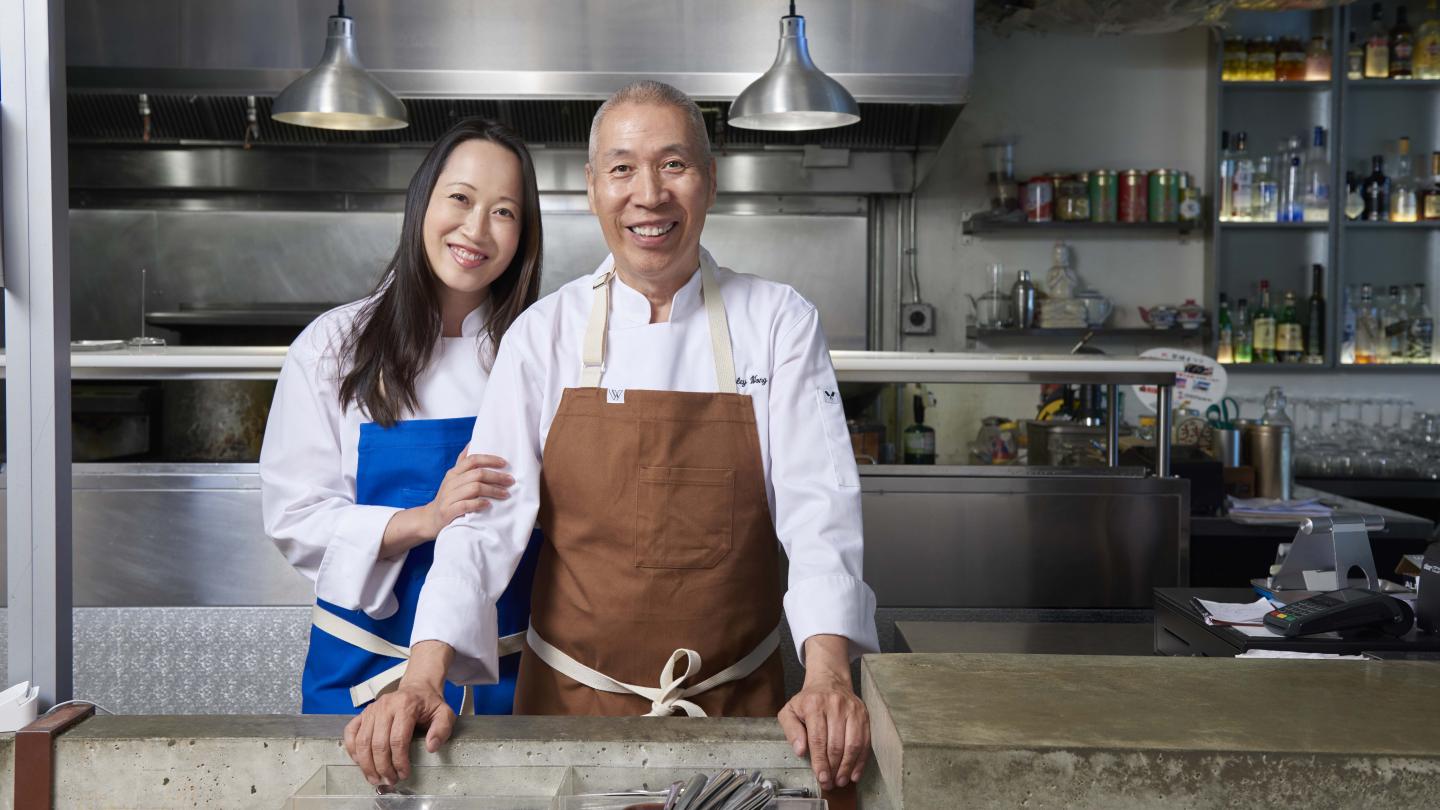 Two chefs smiling in a kitchen