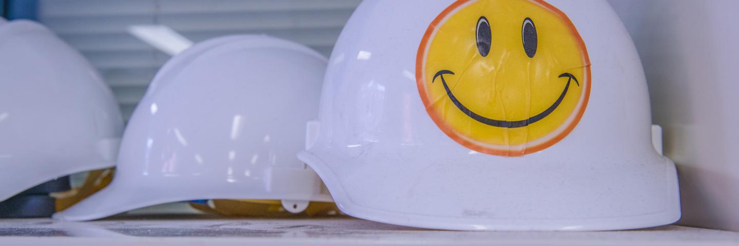 A hardhat with a yellow smiley face on it