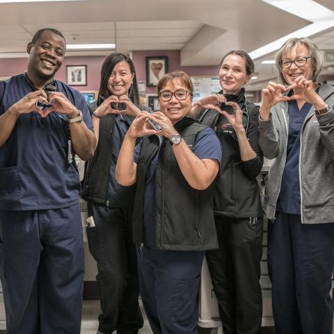 Several staff at the St. Paul's Hospital Heart Centre make heart shapes with their hands.