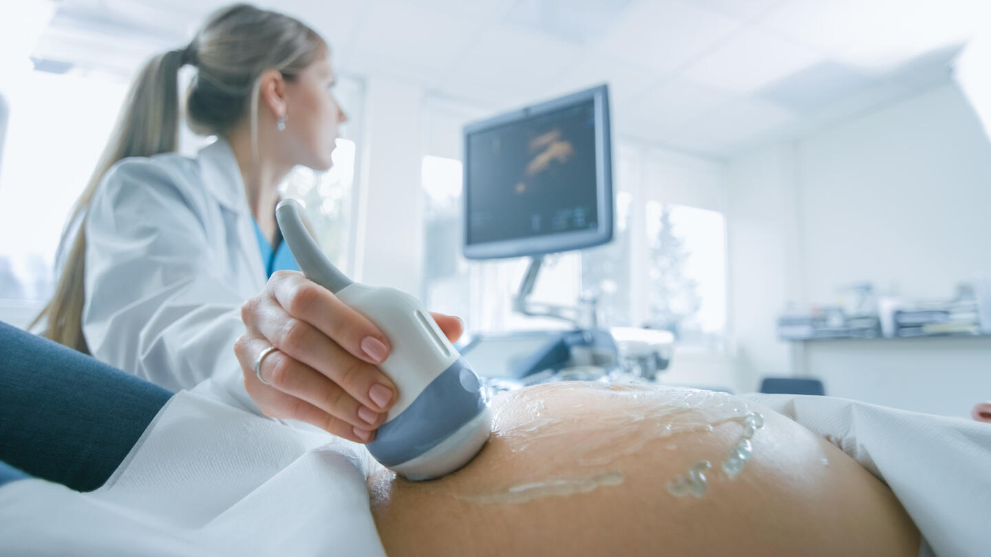 Doctor performing ultrasound on a pregnant woman