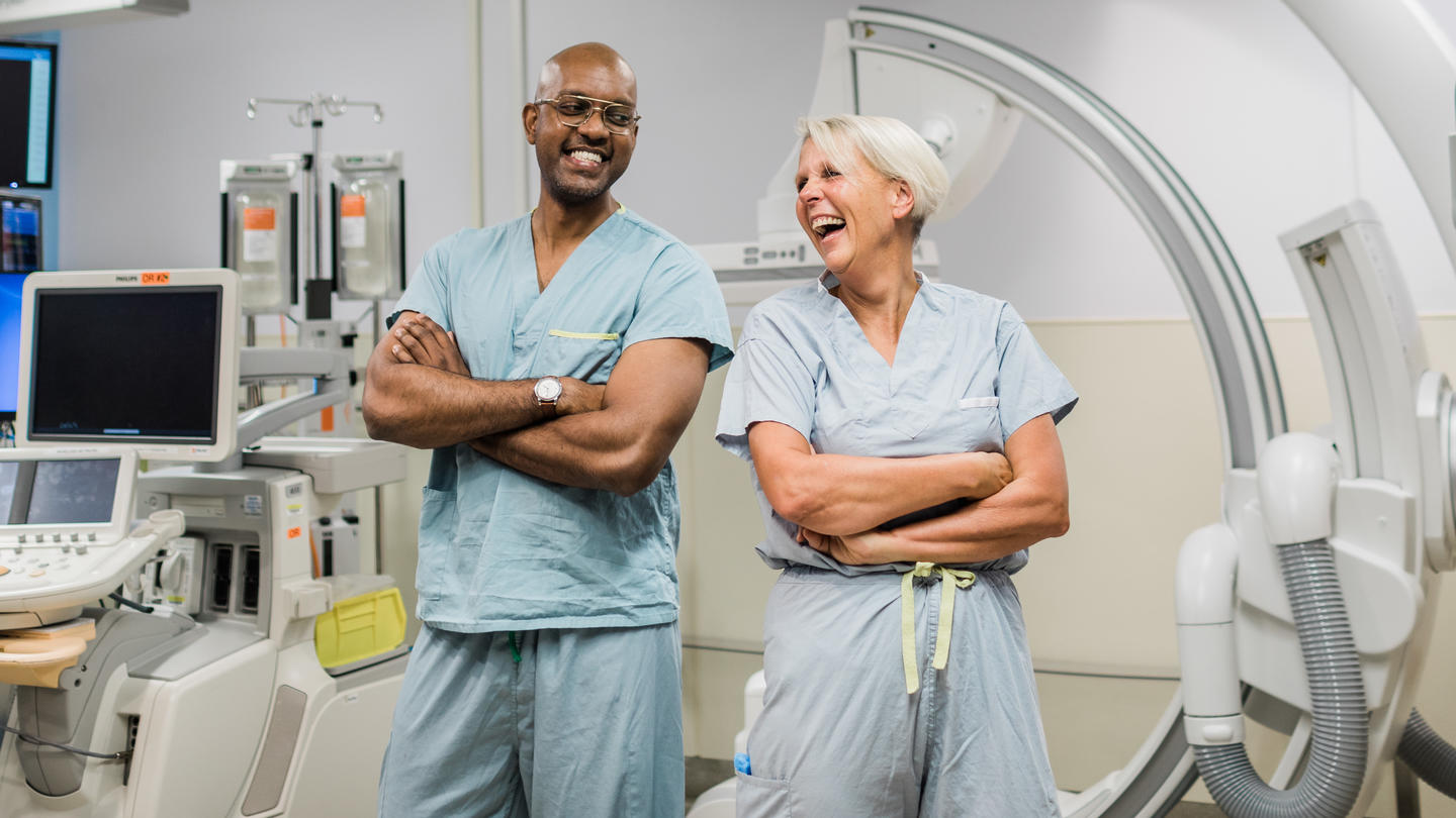 Two surgeons smiling to each other in an operating room