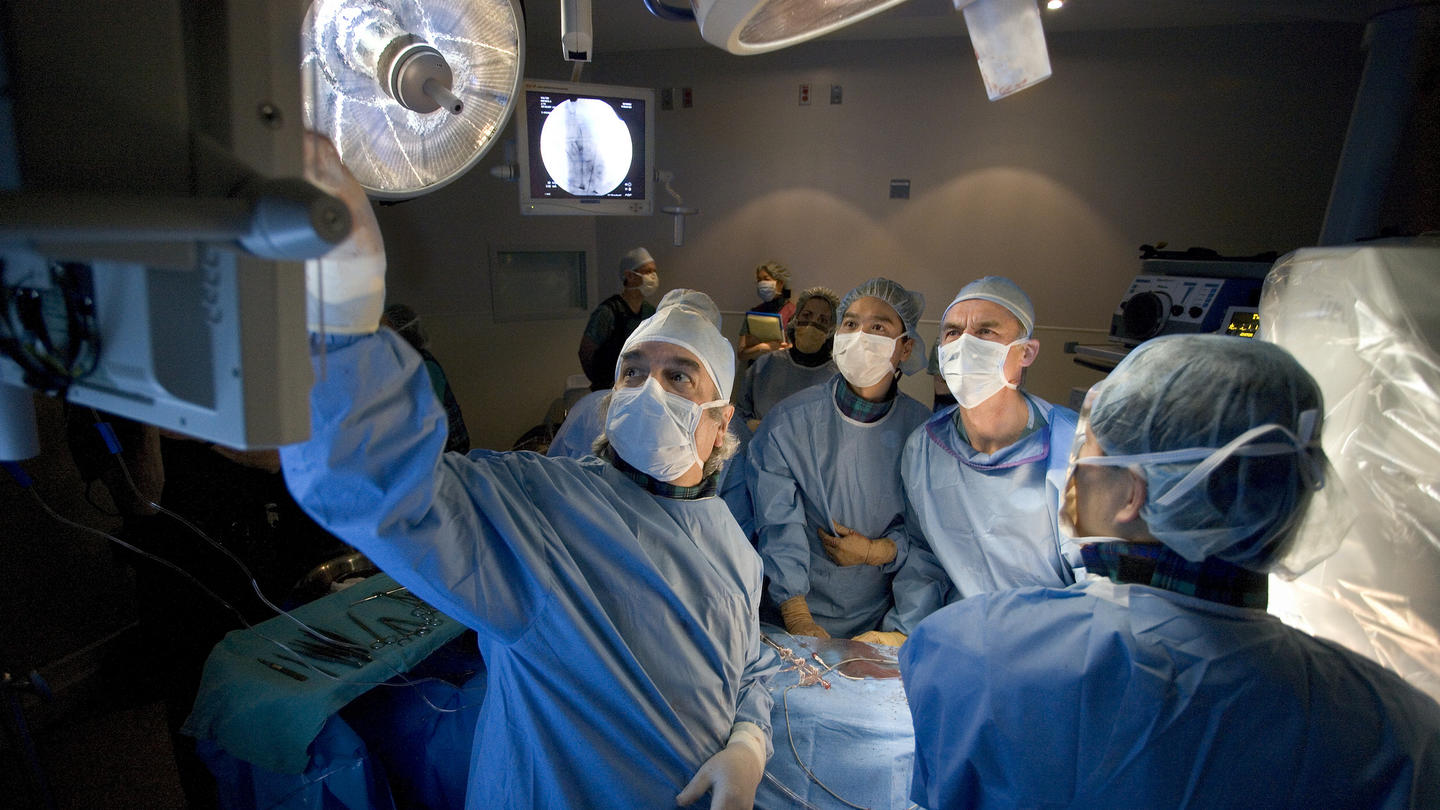 Surgeons performing a surgery and discussing the patient's medical report.
