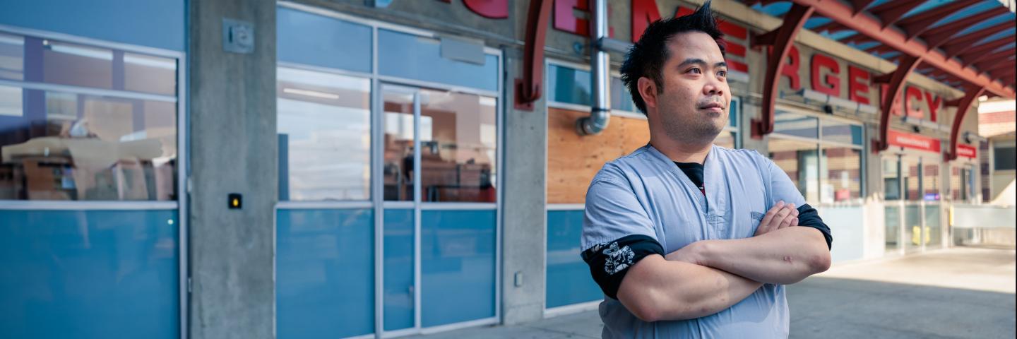 Nurse standing outside the emergency department with arms folded