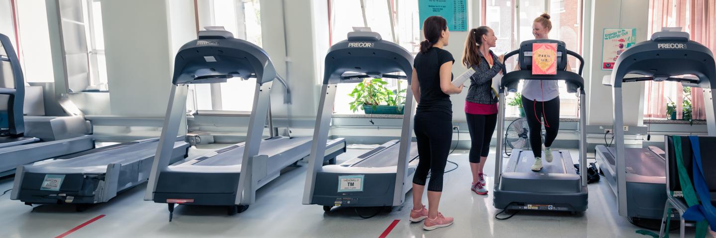 Patient on a treadmill interacting with staff members