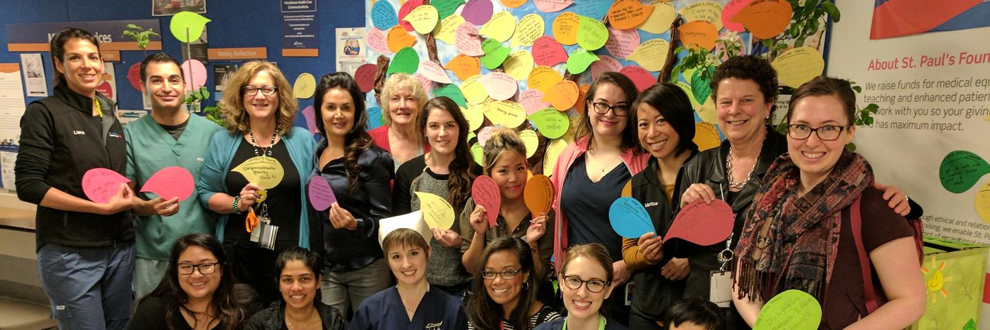 A group of nurses hold up speech bubbles that explain why they love their work