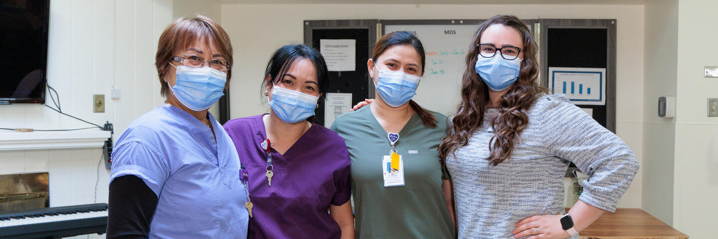 Four long-term care nurses standing side-by-side