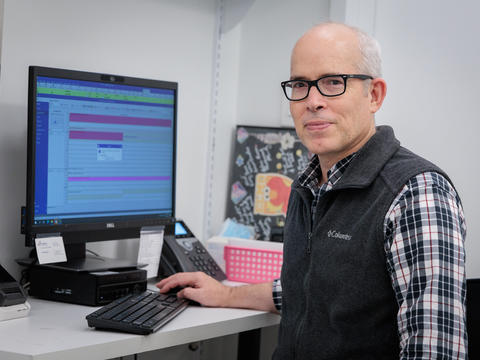 Dr Scott Macdonald sits at a computer at the Crosstown Clinic