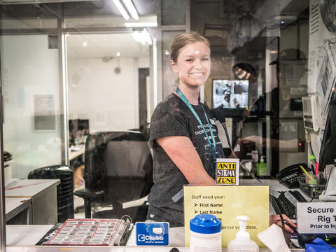 A staff member at the Crosstown Clinic working behind a sign that says No Stigma