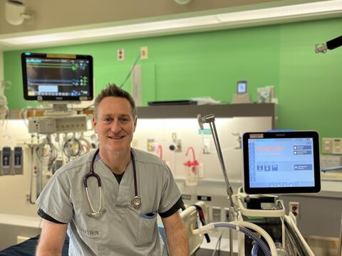 Respiratory Therapist sitting on a bed in the ICU